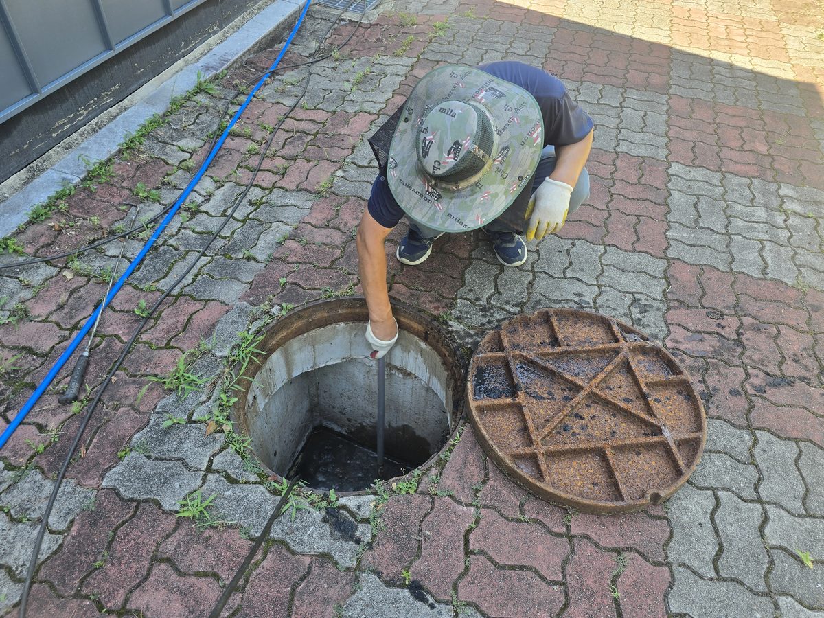 맨홀 점검구를 열고 내부 상태를 확인하는 모습